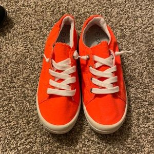 Bright orange slip on sneakers
